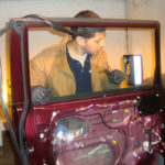 Man replacing auto glass in an antique car