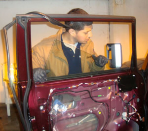 Man replacing antique car's auto glass